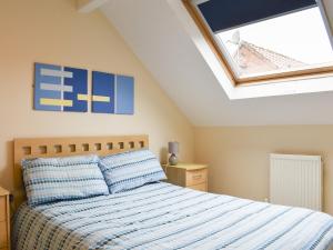 ein Schlafzimmer mit einem Bett und einem Dachfenster in der Unterkunft Riverside Cottage in Whitby
