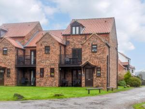 a large brick house with a green yard at Riverside Cottage in Whitby