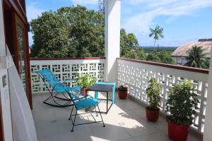 a balcony with blue chairs and a table and some plants at Morona Flats & Pool - 70 m2 in Iquitos