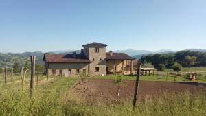 uma casa velha no meio de um campo em Agriturismo Il Filare em Neviano degli Arduini