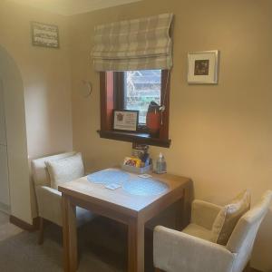 a room with a table and chairs and a window at Craigavon Cottage in Ballachulish