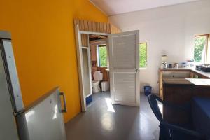 a kitchen with a white door and a yellow wall at Bellavista - Blue Lizard Studio in Providencia