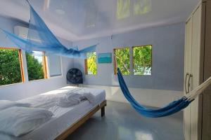 - un lit avec hamac dans une chambre avec fenêtres dans l'établissement Bellavista - Blue Lizard Studio, à Île de la Providence