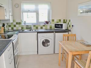 a kitchen with a washing machine and a microwave at Freshwater Bay View in Southwell