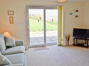 a living room with a couch and a sliding glass door at Freshwater Bay View in Southwell