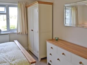 a bedroom with a bed and a dresser and a mirror at Freshwater Bay View in Southwell