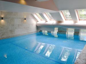 een zwembad met blauw water in een gebouw bij Moorecroft in Buxton