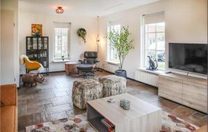 een woonkamer met een flatscreen-tv en meubels bij Beautiful Home In Hoge Hexel With Kitchen in Hoge-Hexel