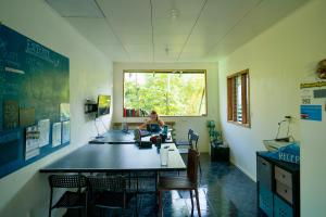 Hostel Esperanza في بافونيس: امرأة تجلس على طاولة في غرفة