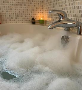 a bath tub filled with bubbles of water at Room in family home near Penny Lane Liverpool in Liverpool