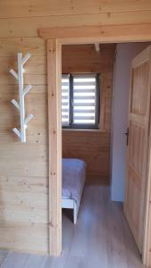 a small room with a bed in a log cabin at Domki Masztowa Przystań in Gąski +15 photos