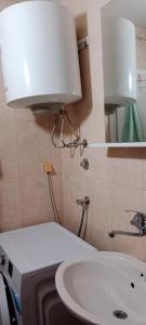 W łazience znajduje się biała umywalka i lampa. w obiekcie Boka Bay w mieście Tivat