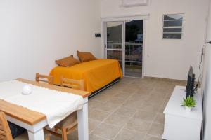 a room with a bed and a table and a television at Apart Las 3 Marias in Chilecito