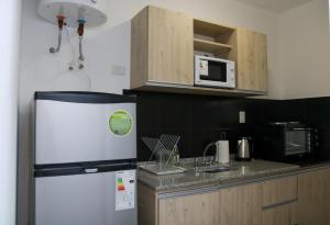 a kitchen with a refrigerator and a microwave at Apart Las 3 Marias in Chilecito