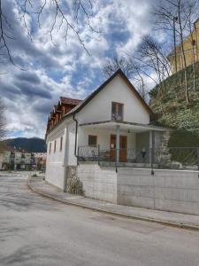 una casa blanca al lado de una calle en Apartma Drev in Bošnjak en Dobrna