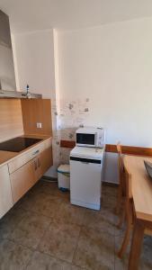 a kitchen with a stove and a sink and a table at Apartment Punta Umbría Luxury in Punta Umbría