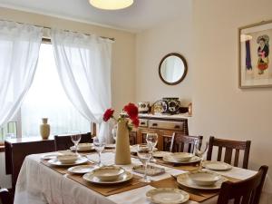 a dining room table with a vase with red flowers on it at Crubisdale in Blairmore