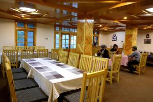 a dining room with a table and people sitting at tables at Arcadian 3Skies Gupis in Gupis +17 photos