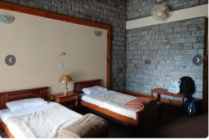 a bedroom with two beds and a chair in it at Arcadian 3Skies Gupis in Gupis