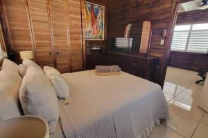 a bedroom with a bed with white sheets and pillows at “La Choza” Beach Cabin en el Poblado de Boquerón in Cabo Rojo