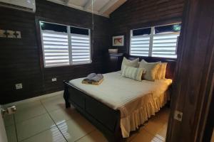 ein Schlafzimmer mit einem Bett und zwei Fenstern in der Unterkunft “La Choza” Beach Cabin en el Poblado de Boquerón in Cabo Rojo