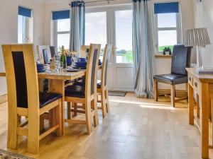 a kitchen and dining room with a wooden table and chairs at Knockinaam House in Colfin