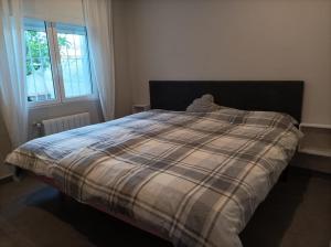 ein Bett mit einer karierten Bettdecke in einem Schlafzimmer in der Unterkunft Chalet Antonio&Ewa in L'Eliana