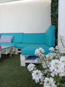 a blue couch in a living room with flowers at Chalet Antonio&Ewa in La Eliana