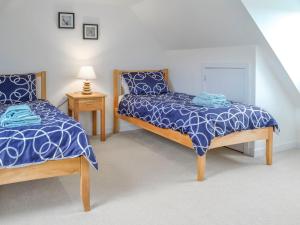 a bedroom with two beds with blue comforters at Knockinaam House in Colfin