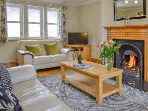 a living room with a table and a fireplace at Knockinaam House in Colfin