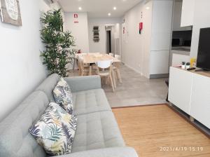a living room with a couch and a dining room at Eanes 22 beach house in Monte Gordo