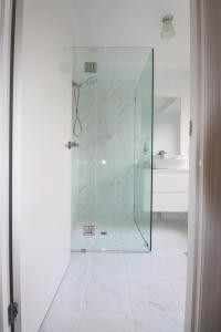 a bathroom with a shower with a glass door at BLK Stays Guest House Deluxe Units Caboolture South in Caboolture
