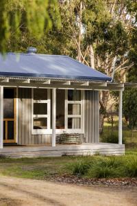 a small house with a blue roof at Lawrence creek cottage Bruny Island in Simpsons Bay