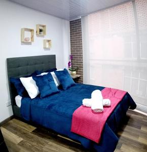 una camera con un letto blu e una coperta rossa di Nuevo Loft completo 34 Corferias Movistar Arena Campin HOST-MI a Bogotá