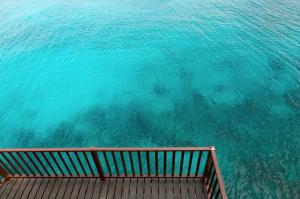 a view of the ocean from a bench in the water at Lagun Ocean View Villa with Own Private Beach in Willemstad