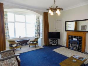 a living room with a fireplace and a television at The Shieling in Lochranza