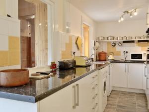 a kitchen with white cabinets and a counter top at The Shieling in Lochranza