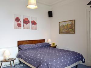 a bedroom with a bed and two pictures on the wall at The Shieling in Lochranza