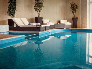 a swimming pool with lounge chairs and a swimming pool at Lawn Lodge in Brockenhurst