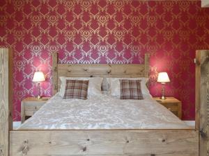 a bedroom with a large bed with red wallpaper at Drummuie House in Golspie