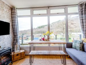 a living room with a table and a large window at Robins Nest in Llanina