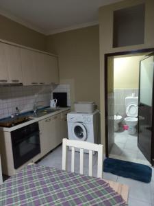 uma cozinha com uma máquina de lavar roupa e um WC em Klev's apartments em Shkodër