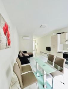 sala de estar con mesa de cristal y sillas en Sliema Apartment in balluta bay en Sliema