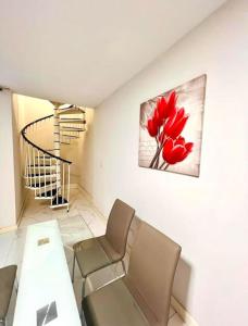 una sala de estar con una pintura de flores rojas en la pared en Sliema Apartment in balluta bay en Sliema