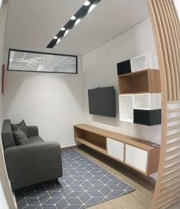 uma sala de estar com um sofá e uma televisão em Nuevo Loft completo 34 Corferias Movistar Arena Campin HOST-MI em Bogotá