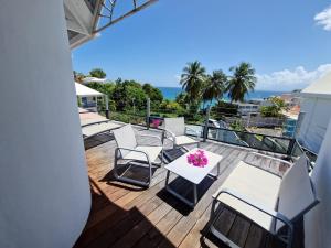 d'un balcon avec des chaises et une table fleurie. dans l'établissement Villa Marbella - Vue mer - Piscine privée - Proche plages, au Gosier