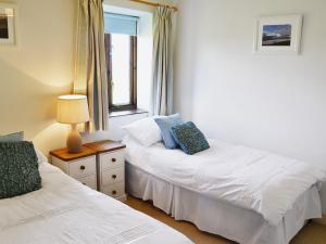 a bedroom with two beds and a window at Harvest Cottage in Padstow