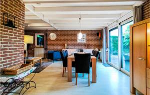 comedor con pared de ladrillo, mesa y sillas en Stunning Home In Wolphaartsdijk With Kitchen, en Wolphaartsdijk