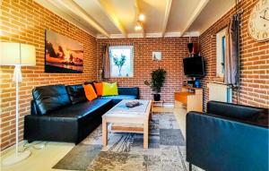 sala de estar con sofá de cuero negro y mesa en Stunning Home In Wolphaartsdijk With Kitchen, en Wolphaartsdijk