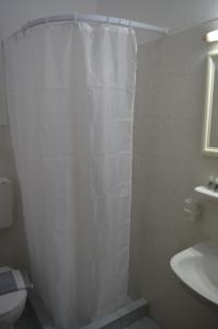 a bathroom with a shower curtain and a sink at Junction studios in Skiathos Town